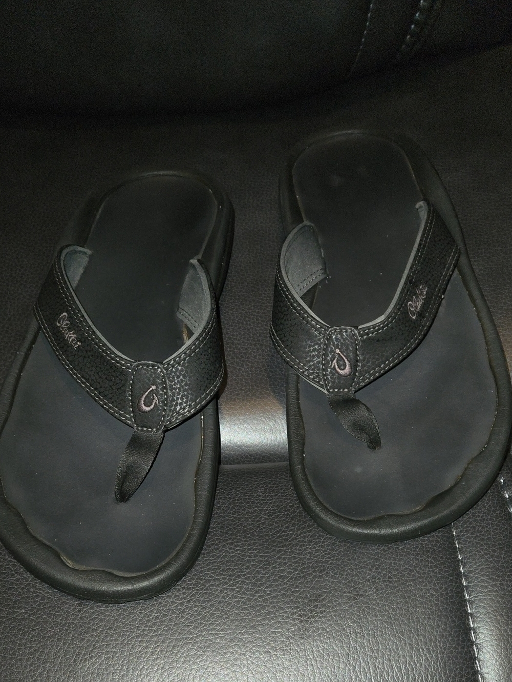 Black OluKai 'Ohana Sandals, featuring water-resistant synthetic strap